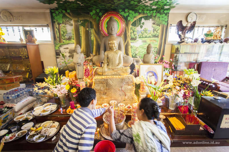 Making prayers in front of statues of Buddha.