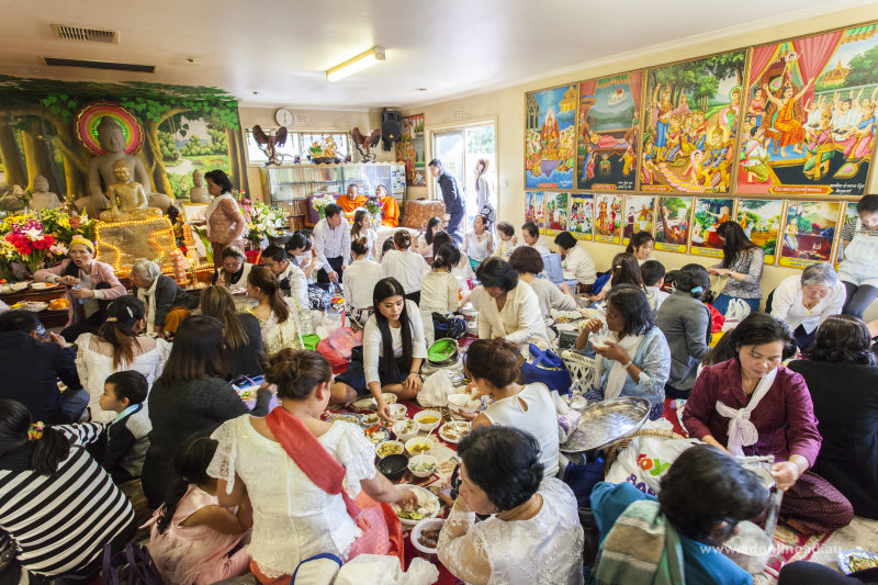 Families eating meals on the floor of the temple.