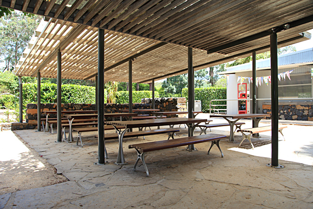 Picnic tables sheltered under a roof.