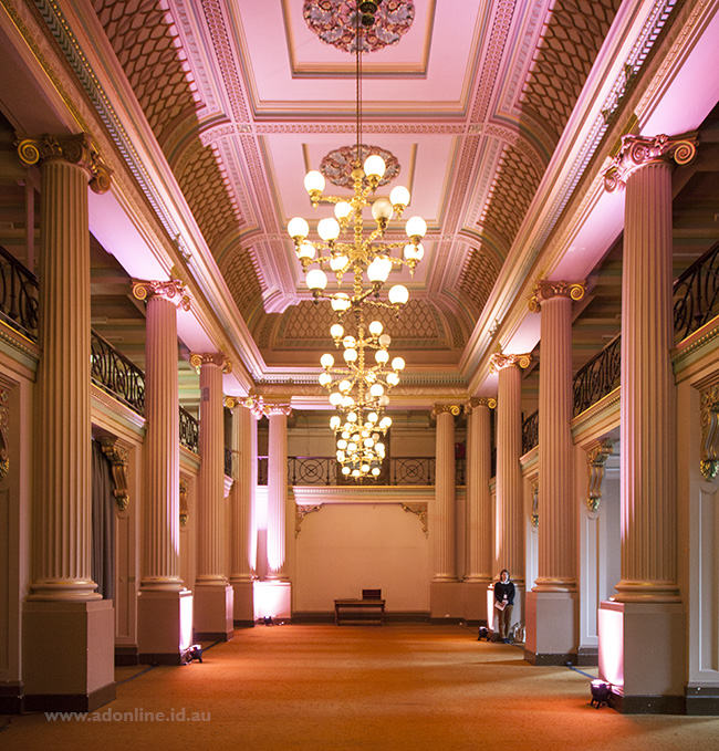 Room interior showing large hall with columns and pink-coloured illumination